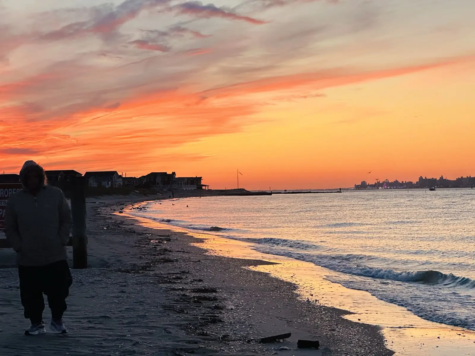 Sunset over the water at the edge of Brooklyn with the city skyline on the horizon