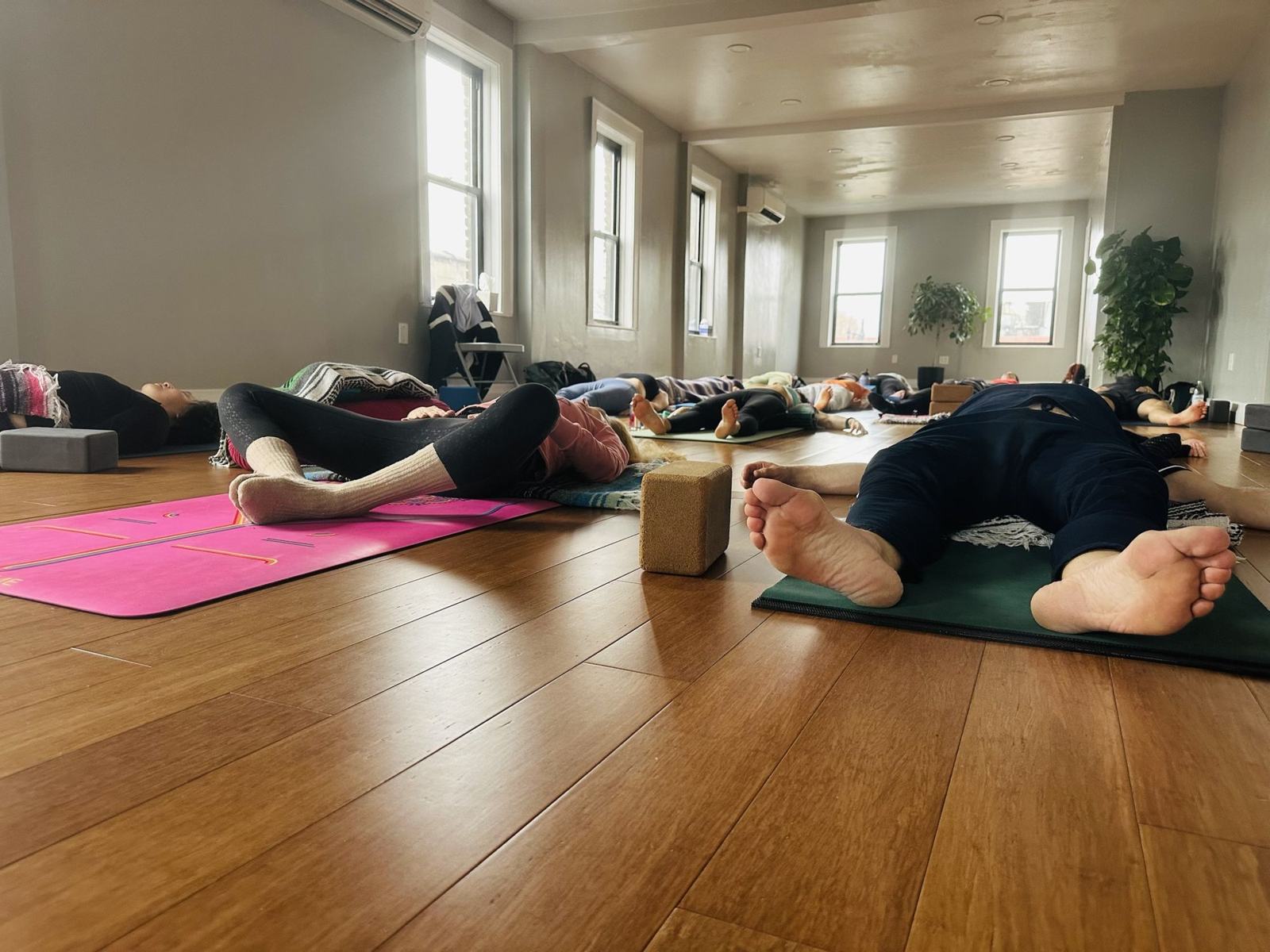 Students resting in savasana at the end of class