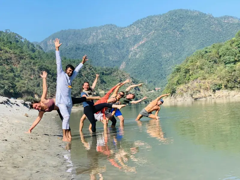A group stretching together in the shallows of the river