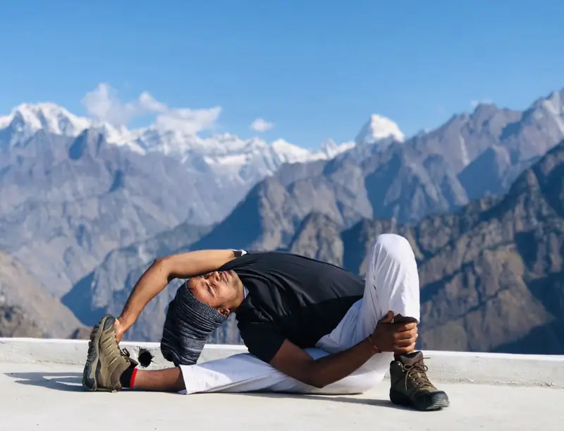 A seated twist with snow-capped Himalayan peaks behind