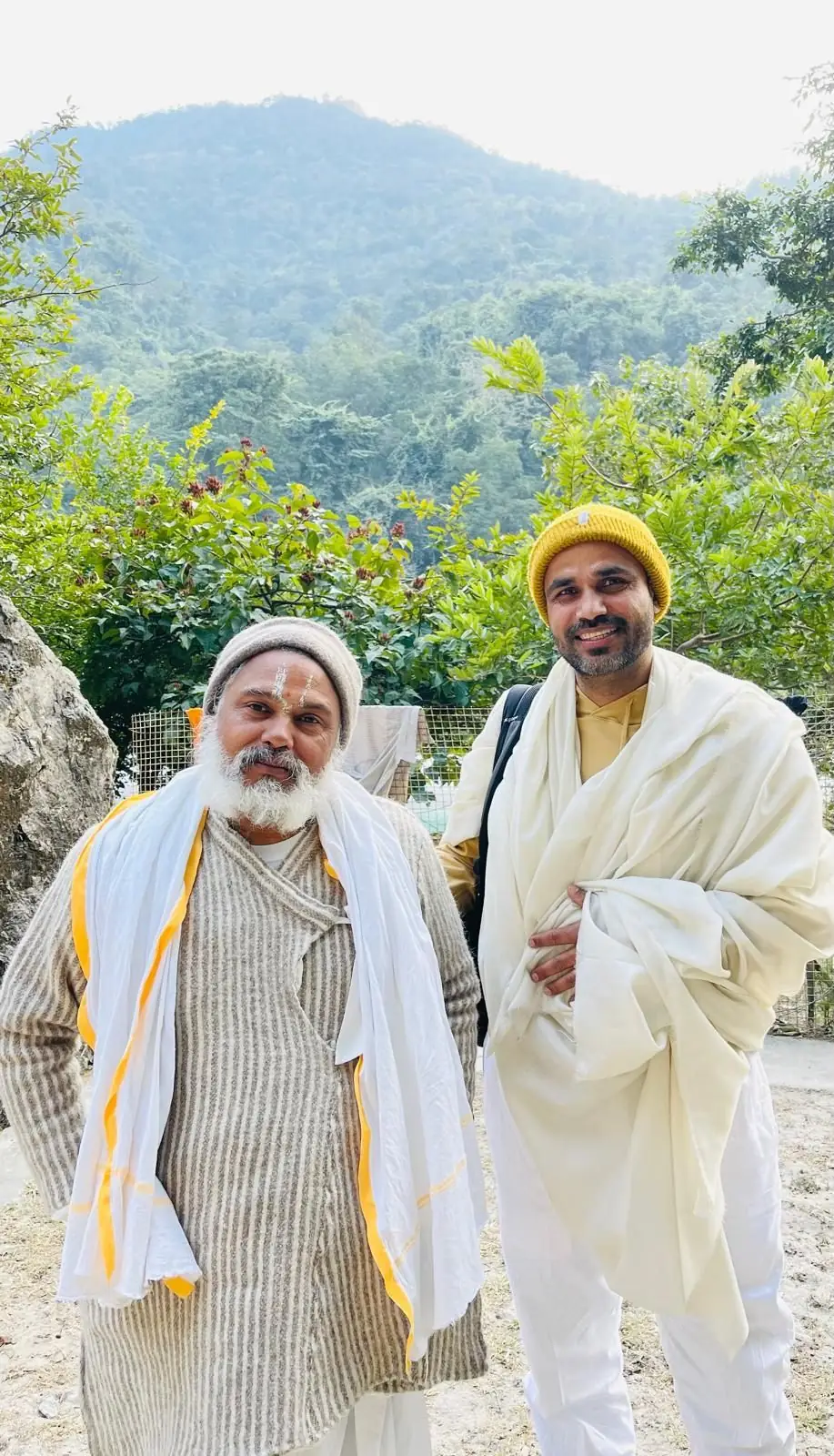 A sadhu and a teacher smiling together in the hills of Rishikesh