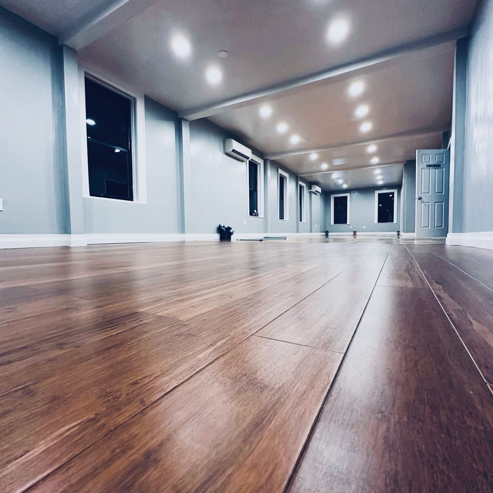 The empty Samadhi Hall in the Brooklyn studio, with bamboo floors and soft evening light